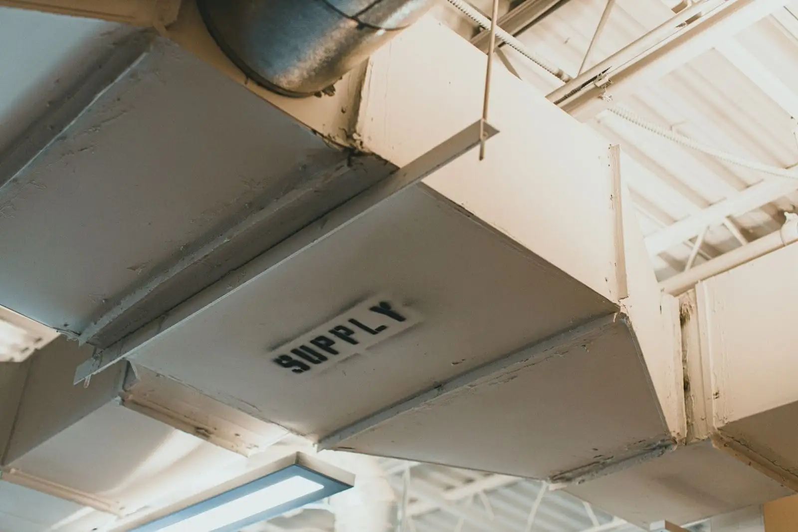 Overhead supply ductwork in a serviced mechanical space